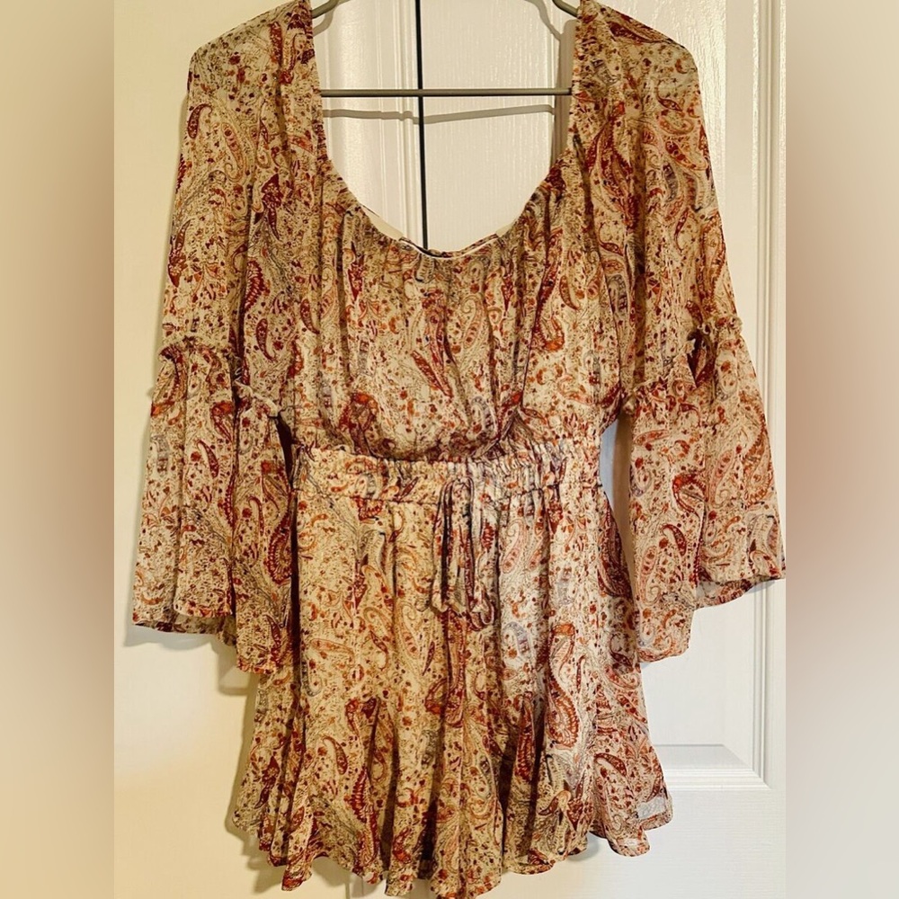 Francesca’s long sleeve paisley romper with thin gold threading details.